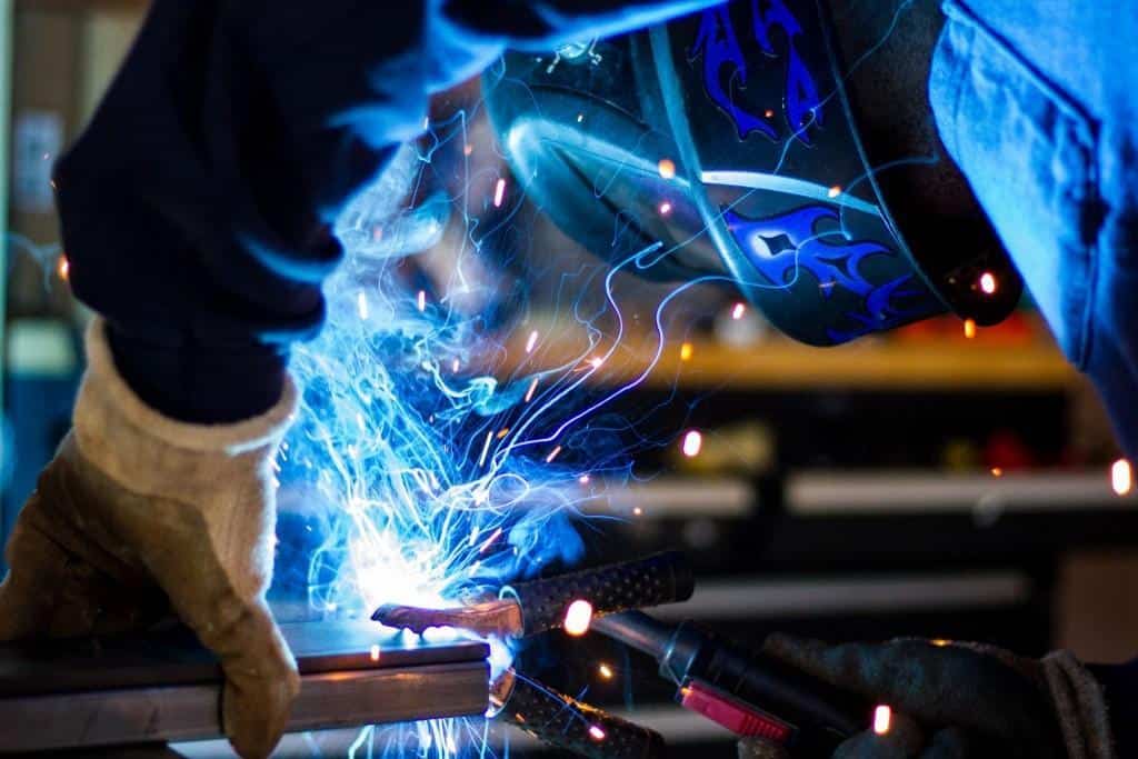Blue sparks from a person wielding steel. Photo by Rob Lambert on Unsplash
