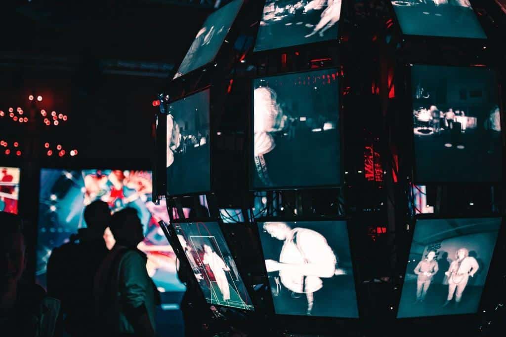 number of screens in a dark room. Photo by Maxim Hopman on Unsplash
