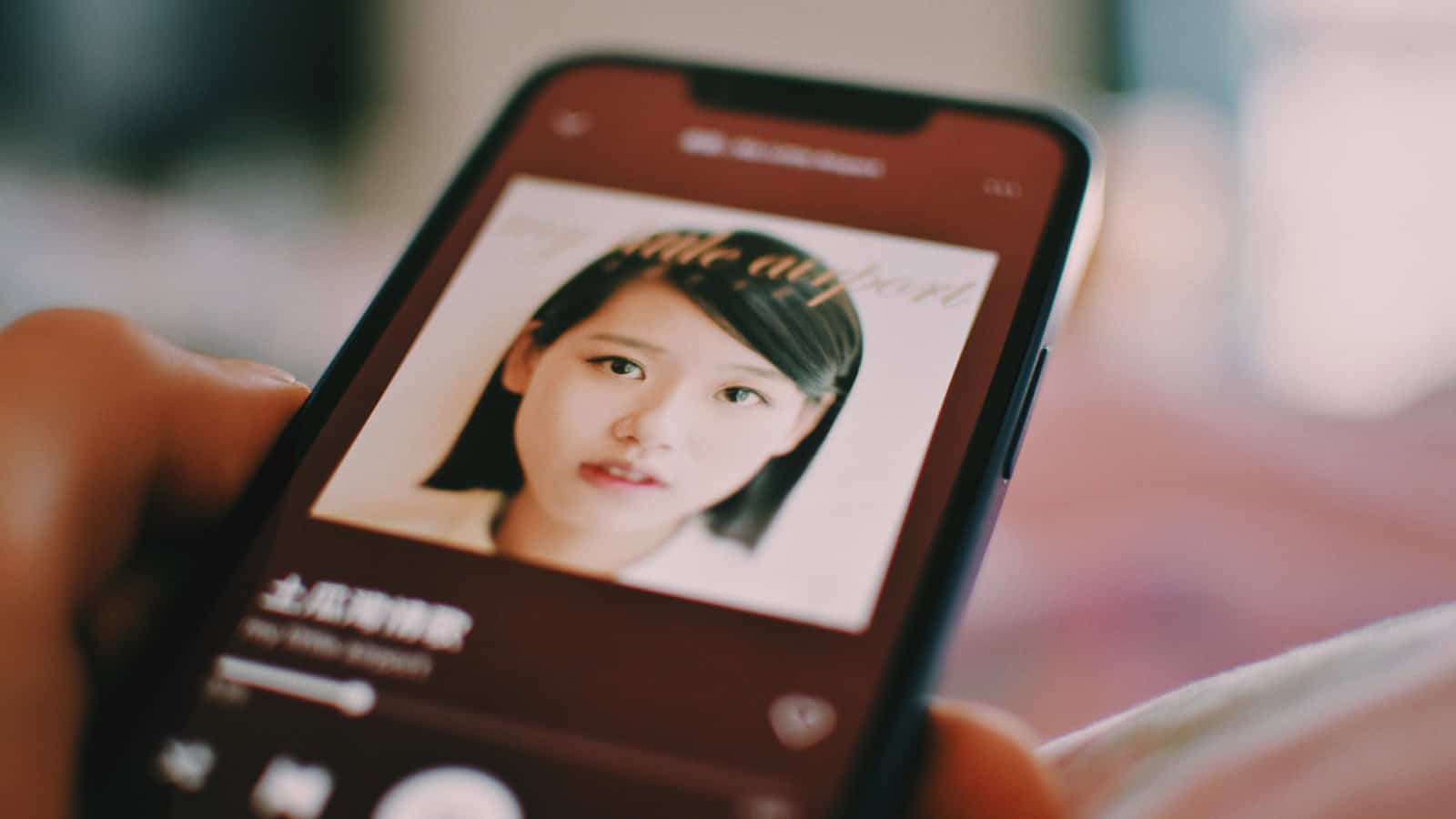 Person holding a smartphone with a face photo displayed on screen