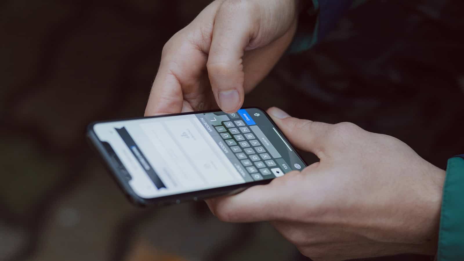 Hand typing on a smartphone keyboard