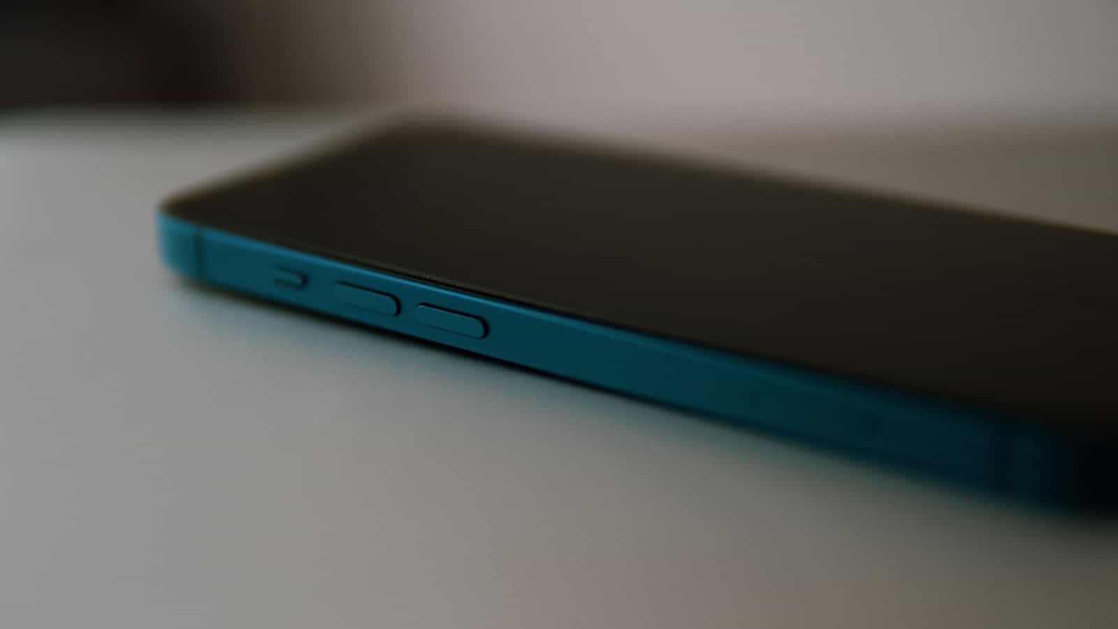 A close view of the edge of a teal phone showing its side buttons.