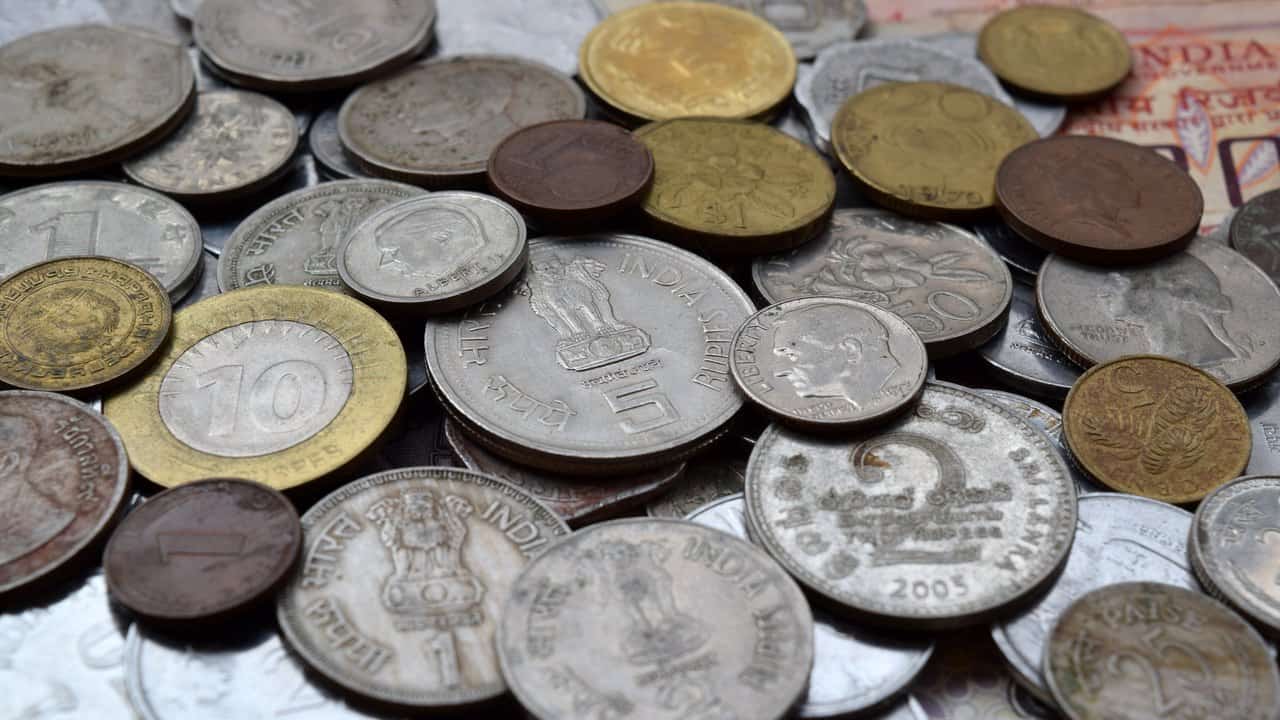A dense spread of assorted circulated coins of different denominations and ages