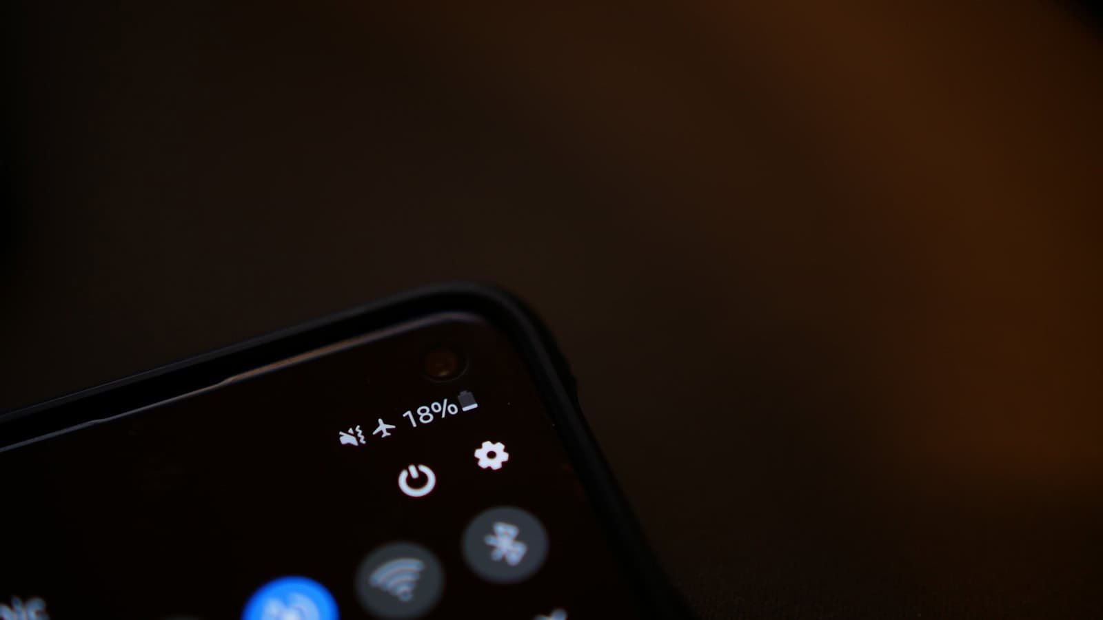 A close-up of an Android status bar and quick settings showing an 18 percent battery.