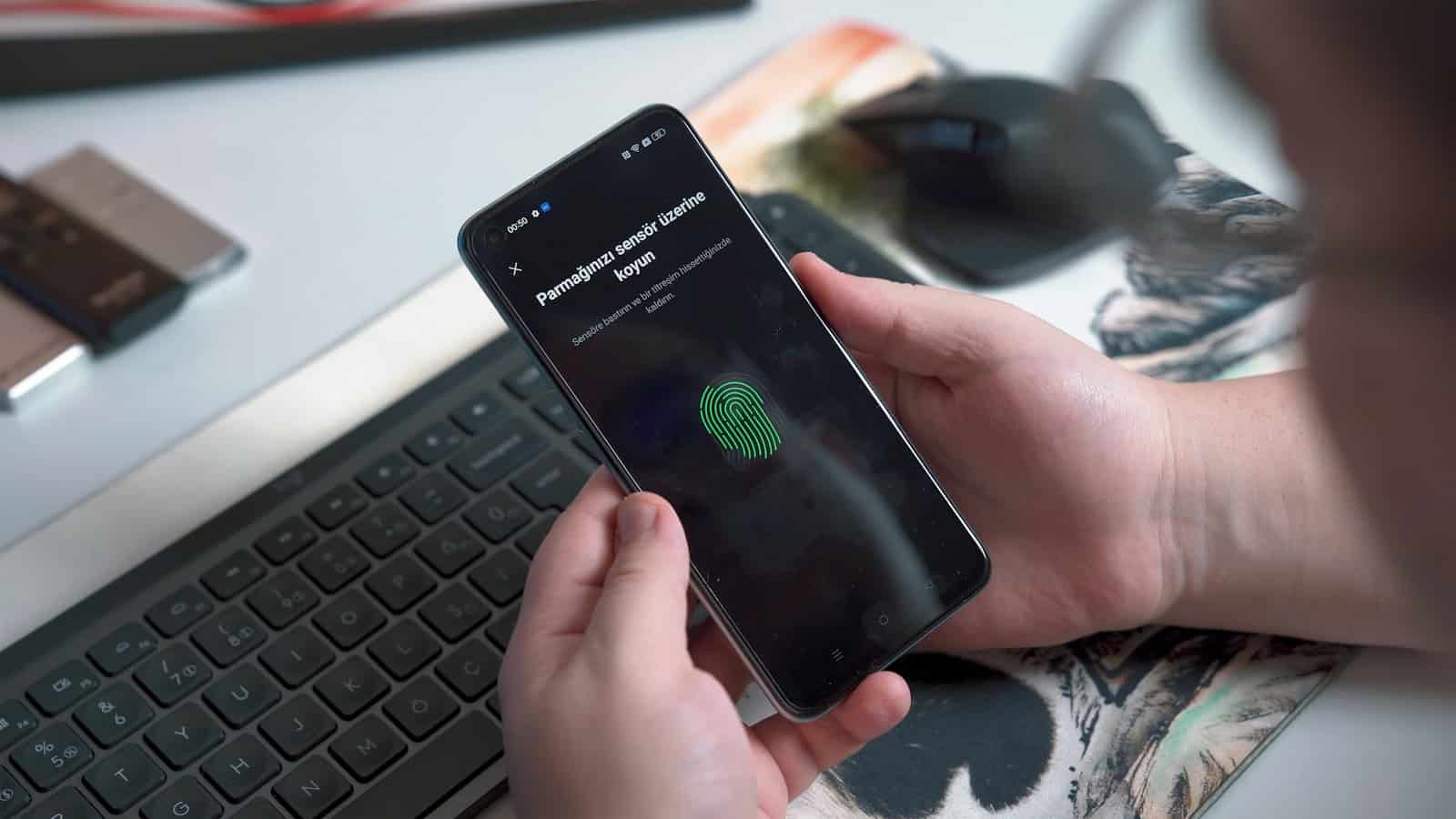 A person holding an Android phone that is showing a fingerprint verification prompt.