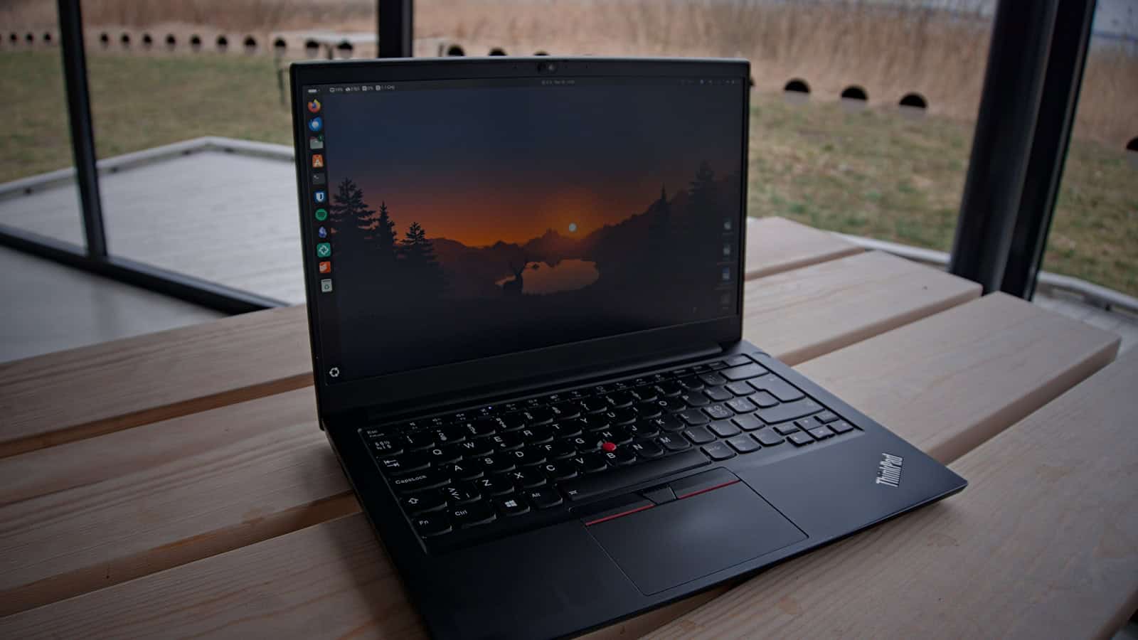 A Lenovo ThinkPad open on a table, its screen dark.