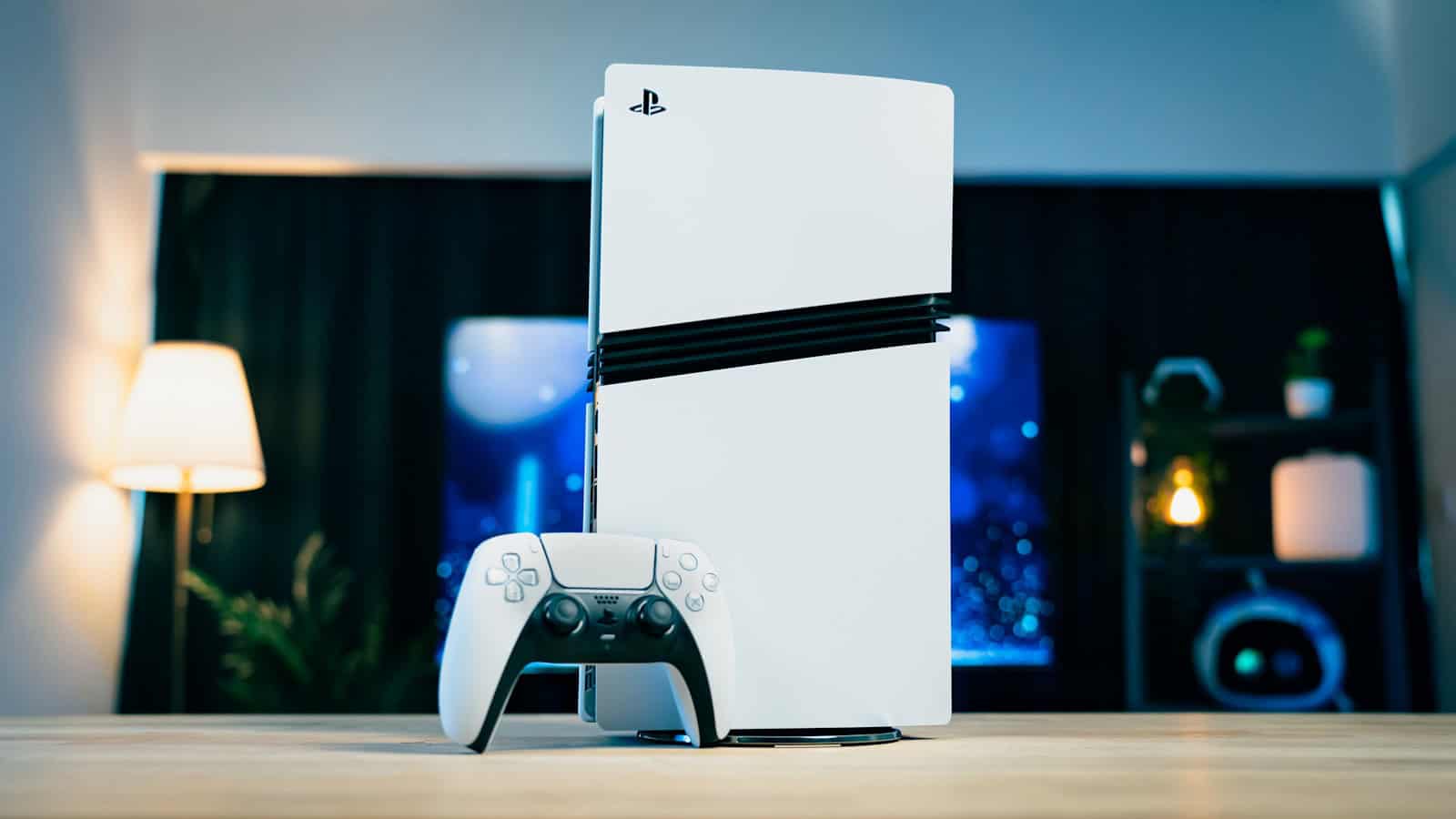 A PlayStation 5 standing upright on a desk beside its DualSense controller.