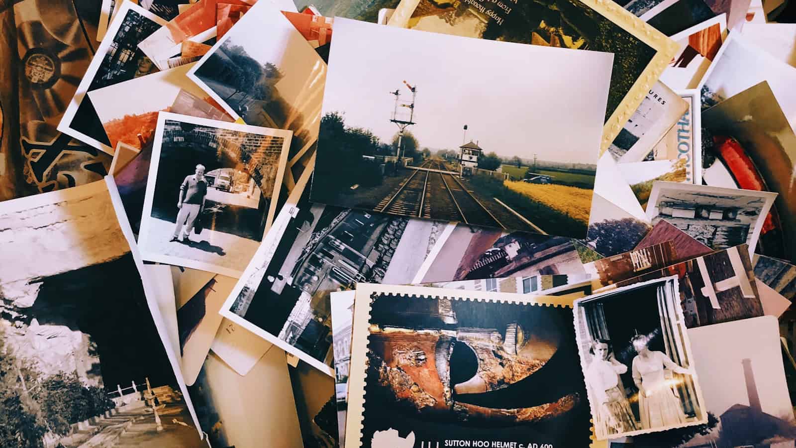 A jumbled pile of old printed photographs and postcards.