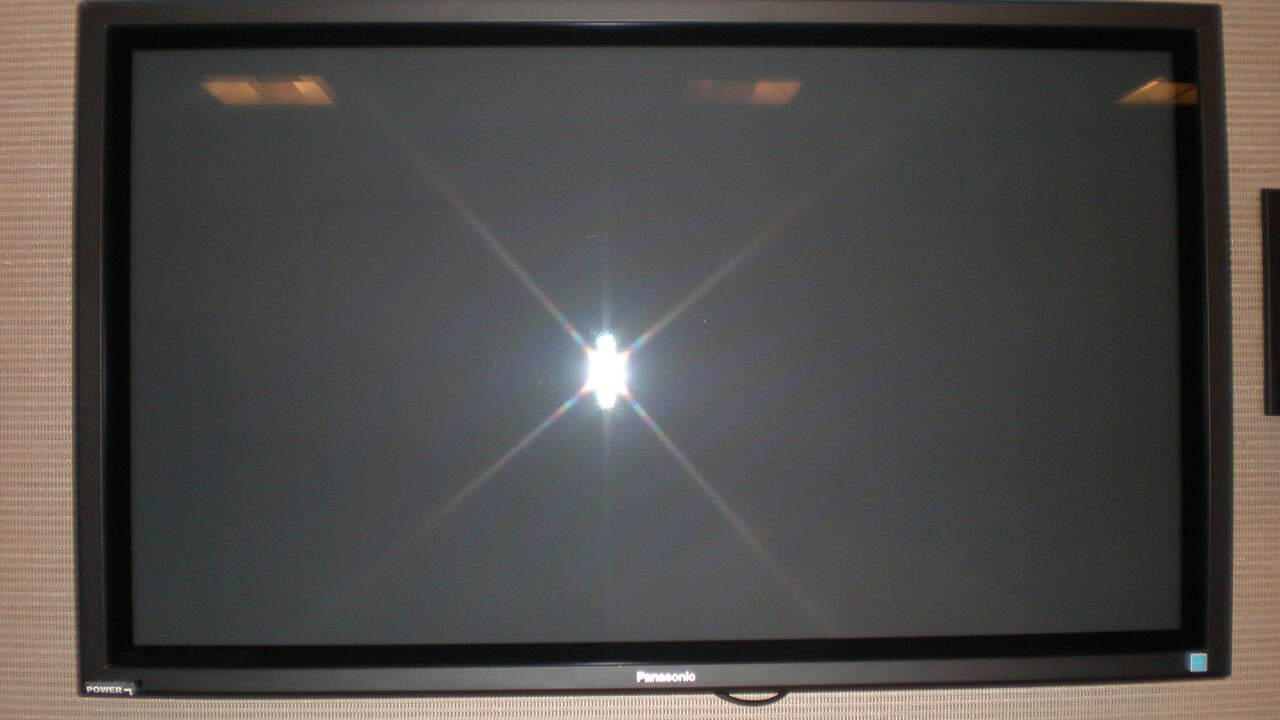 A wall-mounted flat-screen TV with a dark, unlit screen