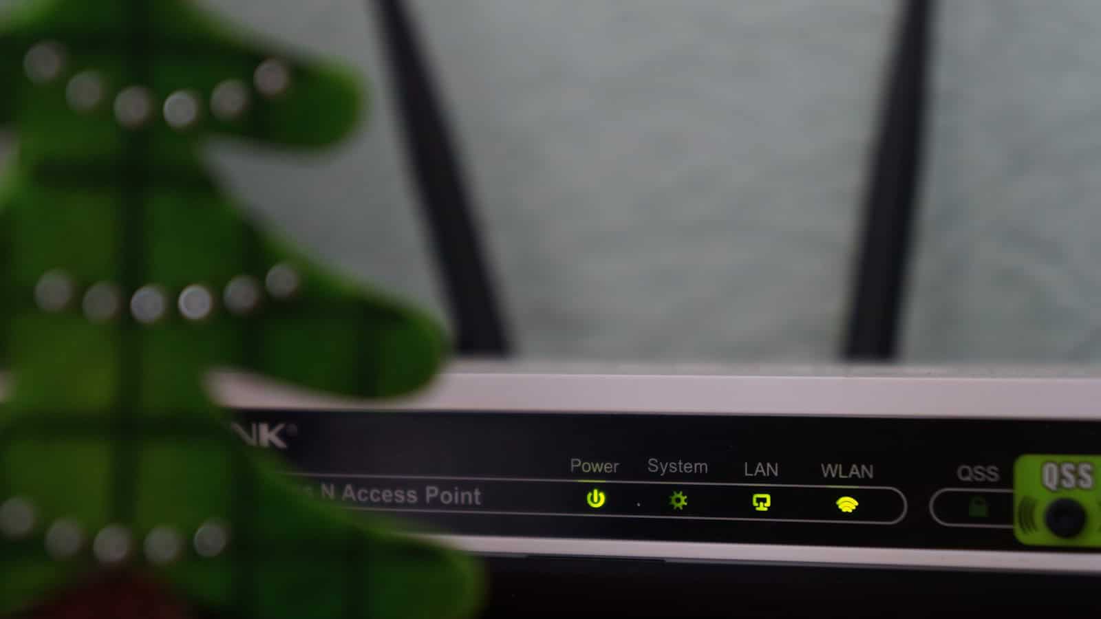 A row of lit status LEDs on the front of a white wireless access point.