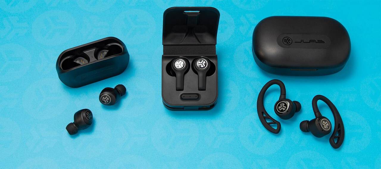 JLab true wireless earbuds with their charging cases on a blue background.