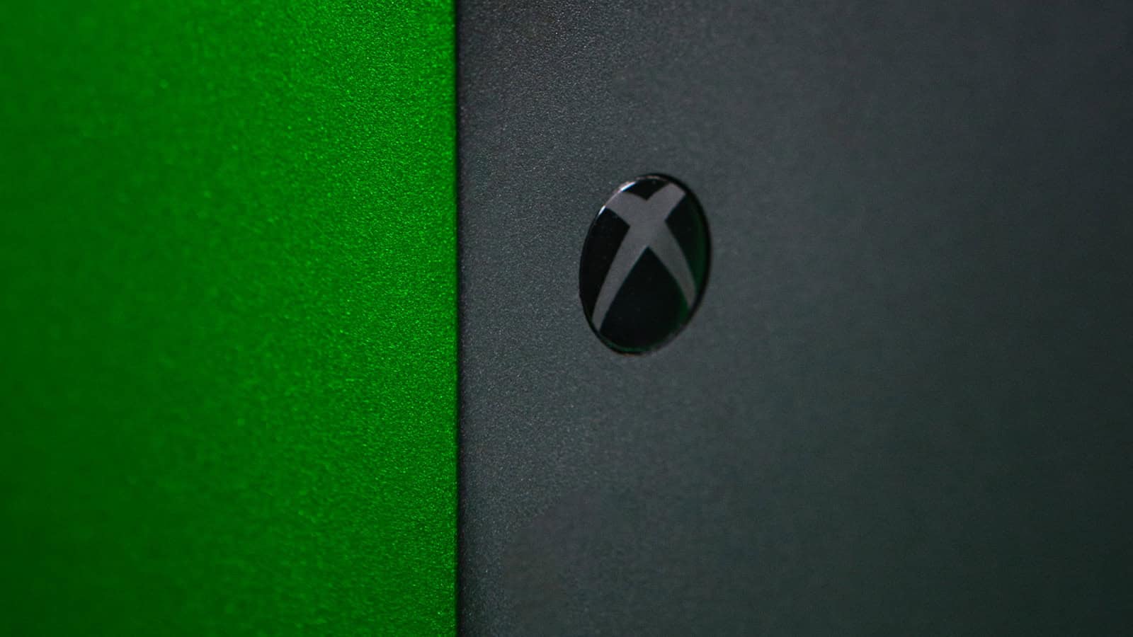 Close-up of the illuminated Xbox logo on the front panel of an Xbox Series X, which is the console's power button.